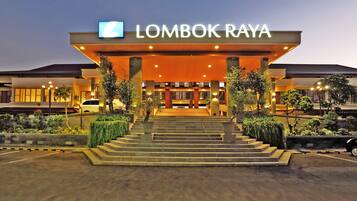 A hotel entrance with a sign reading "LOMBOK RAYA" and a staircase leading up to the entrance.