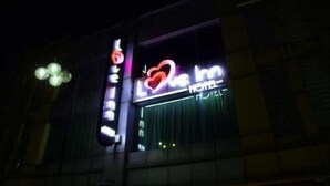 Placa de hotel com um símbolo de coração e o nome 'Love Inn'.