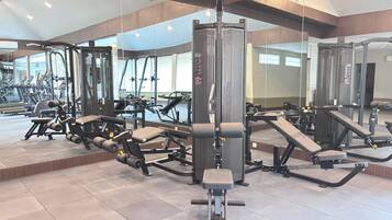 Een sportschool met diverse trainingsapparaten, grote ramen en een modern design.