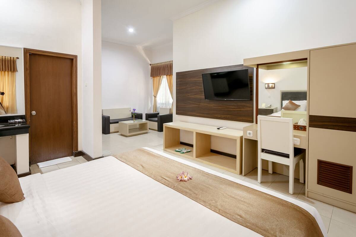 A hotel room with a bed, a TV, a desk, and a wardrobe.
