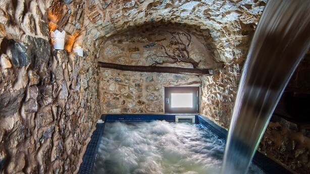 A stone-walled hot spring bath with a wooden beam ceiling and a small window. - Wundergarten Dimora dei Frati (Gratteri)