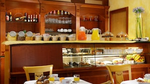 Un buffet de petit-déjeuner proposant une variété d'aliments, de boissons et de verrerie.