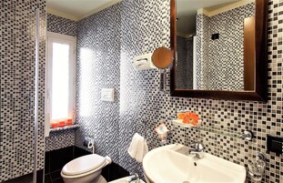 Un bagno con servizi igienici, lavandino e specchio.
