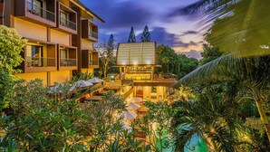 A modern hotel with multiple balconies, a pool area, and lush greenery. - Pandawa All Suite Hotel (Kerobokan)