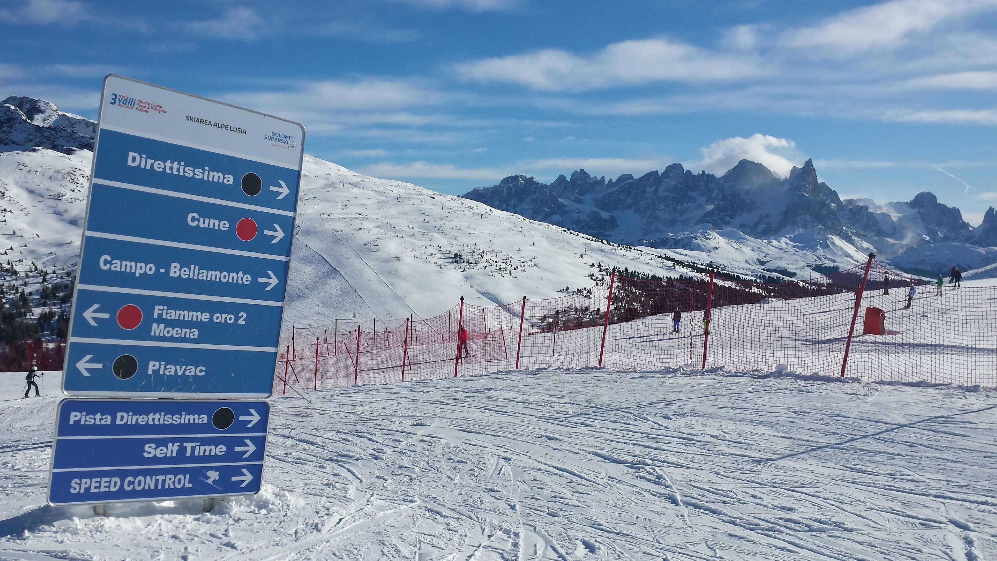 A directional sign at a ski resort with multiple arrows pointing to various destinations.