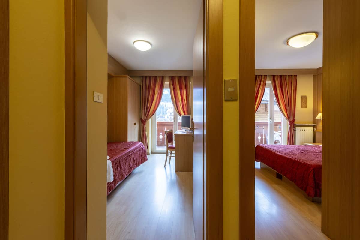 A hotel room with two beds, a desk, and a chair.