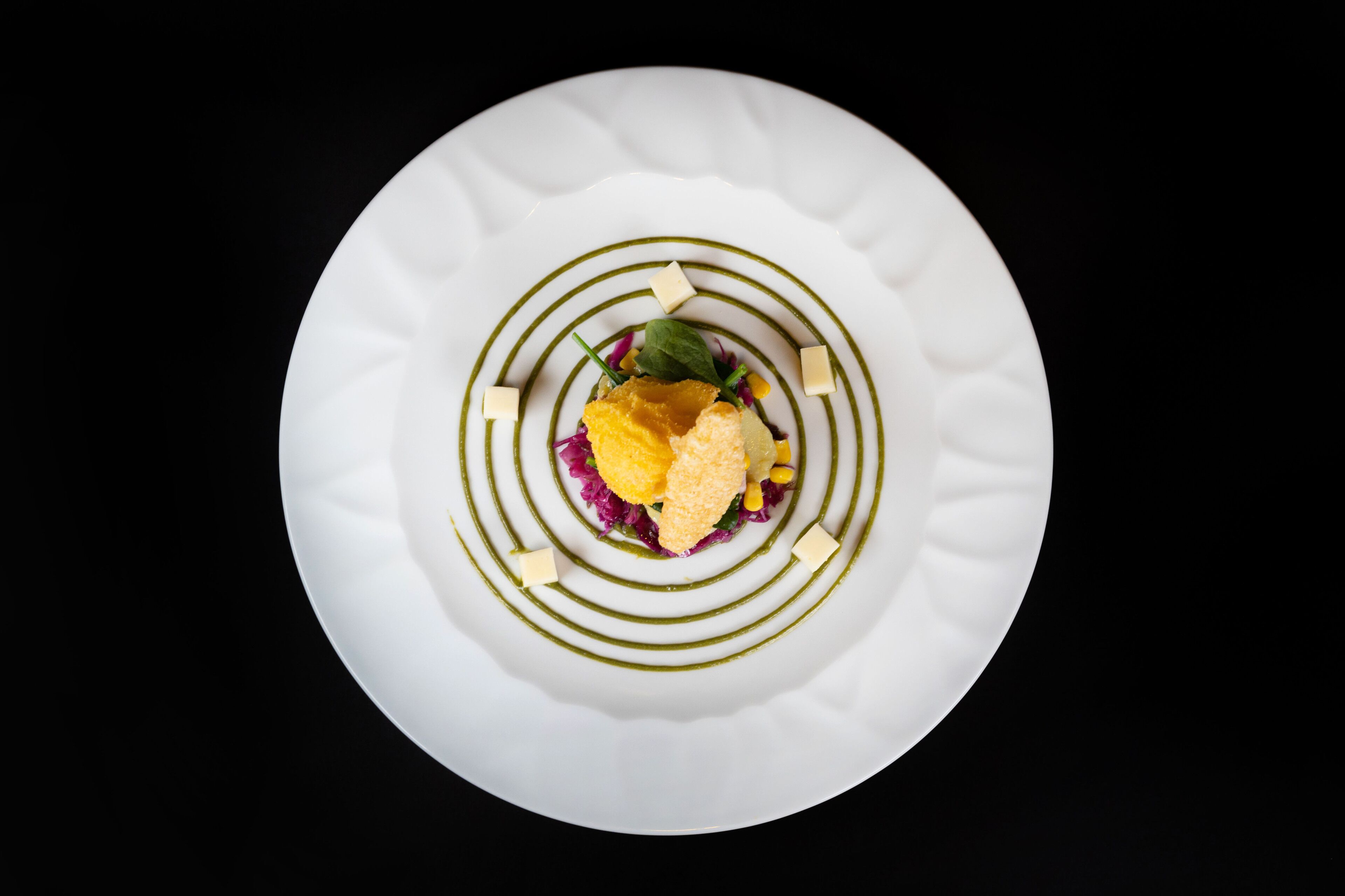 A white plate with a spiral design and a central garnish.