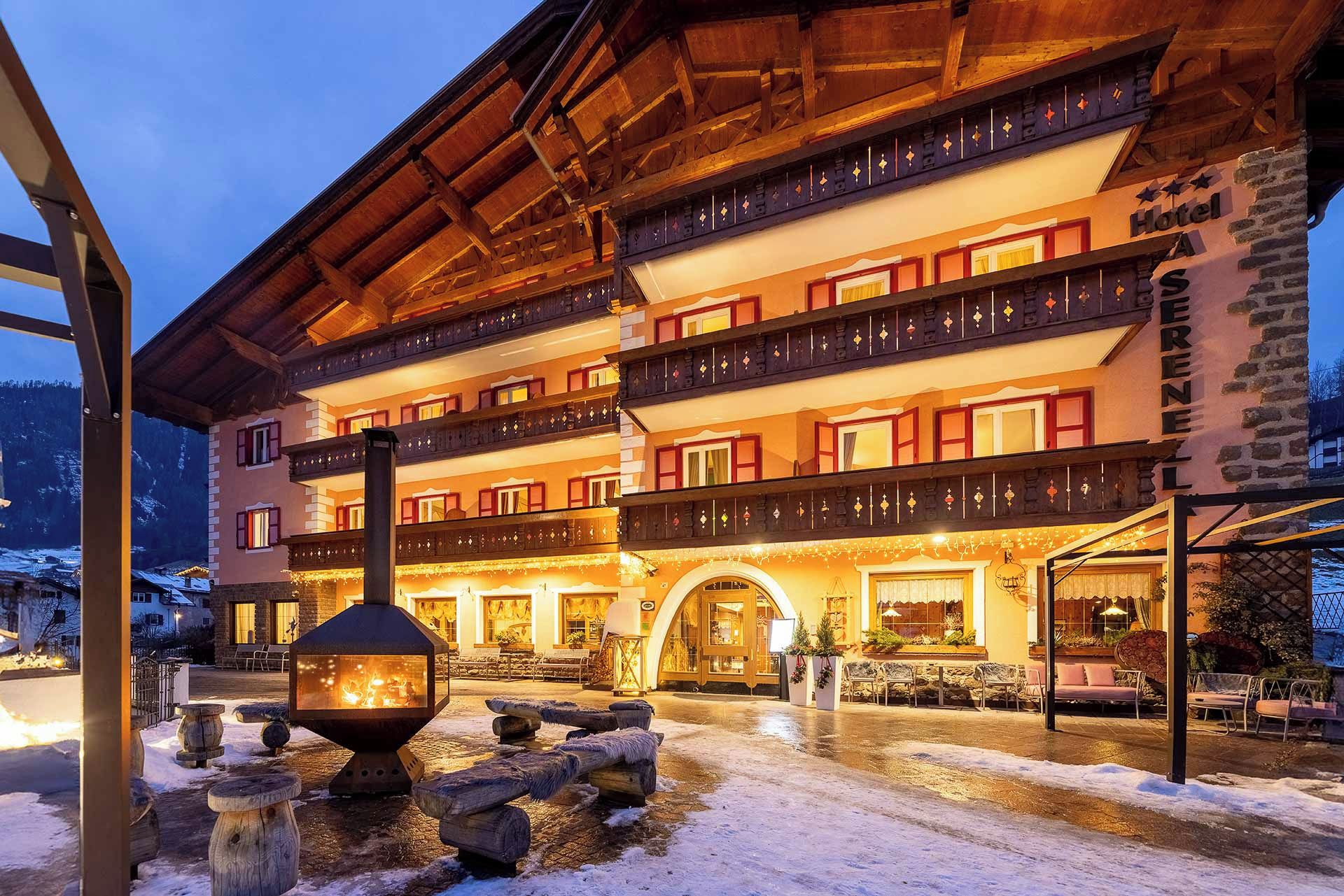 A multi-story hotel with balconies, a fireplace, and outdoor seating.