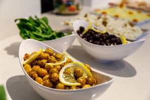 A table with bowls of food, including chickpeas and black beans, and a plate of rice. - Urban Hotel Bomonti (Istanbul)