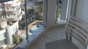 Ein Balkon mit Blick auf das Meer und einen Poolbereich.