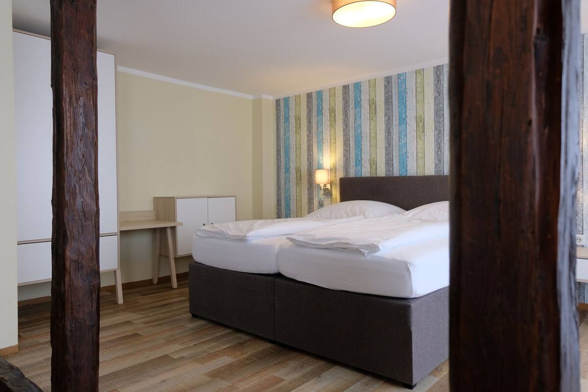 Ein Hotelzimmer mit einem Bett, einem Schreibtisch und einer gestreiften Wand.