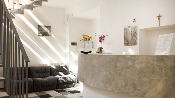 Ein modernes Interieur mit Treppe, einer Couch, einem Marmor-Rezeptionsschalter und Wanddekorationen.