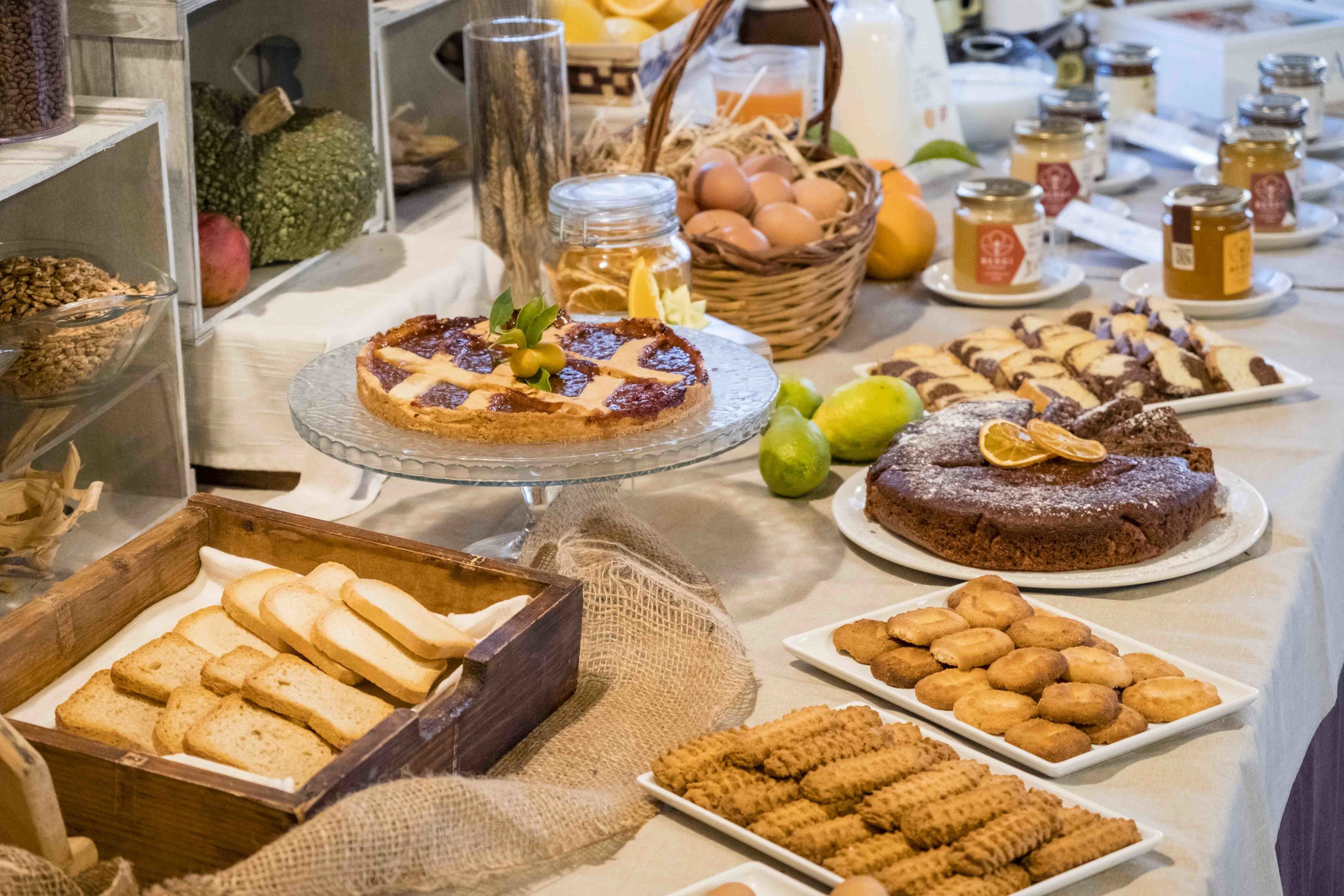 A buffet with various food items including pastries, cakes, and fruits.