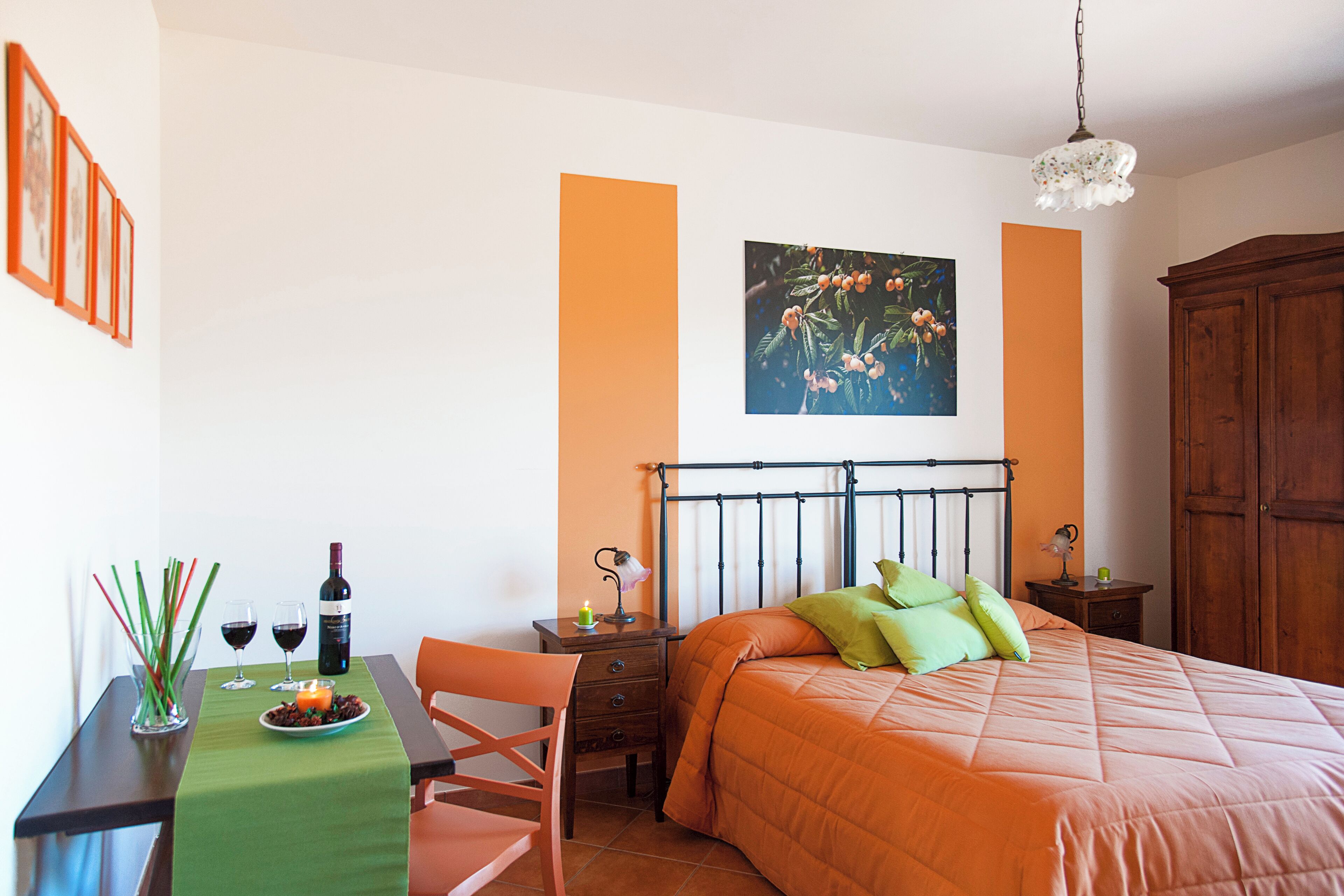 Ein Schlafzimmer mit einem Bett, einem Nachttisch, einem Tisch mit grüner Tischdecke und einem Stuhl.