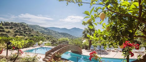 Una piscina al aire libre de temporada, sillones reclinables de piscina