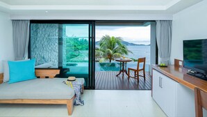 Un dormitorio moderno con una cama grande, un televisor y vistas a una piscina y al océano.