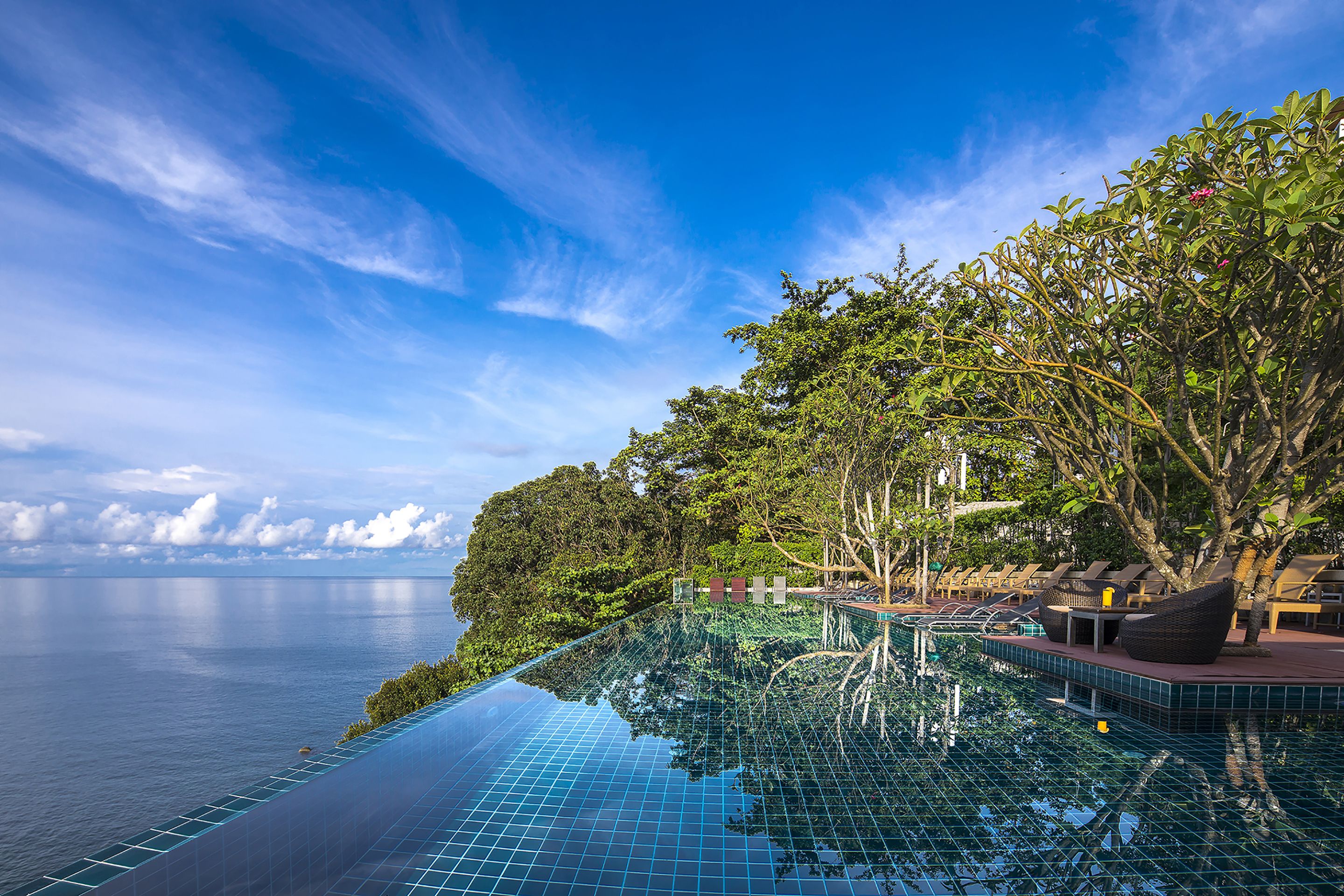Una piscina al aire libre, sombrillas, tumbonas