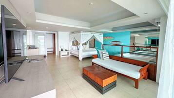 A hotel room with a large bed, a sofa, a TV, and a balcony with a view.