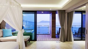Un balcón con vista al mar y a las montañas, un sofá y una mesa.