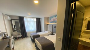A hotel room with two beds, a desk, a chair, a small table with a kettle, and a bathroom visible through an open door. - Sahil Hotel Pendik (Istanbul)