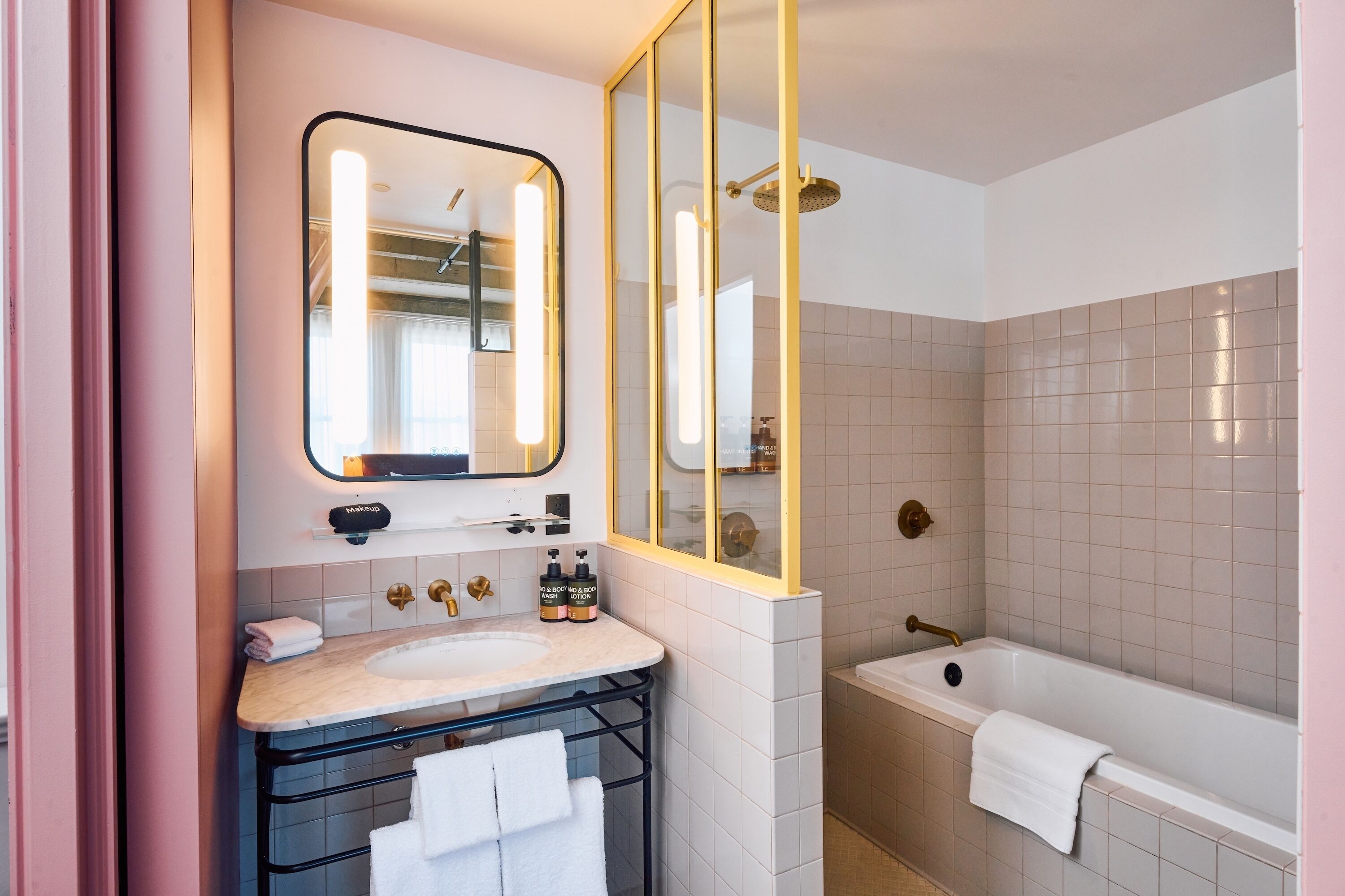 Une salle de bain moderne avec un grand miroir, un lavabo, une baignoire et une douche.