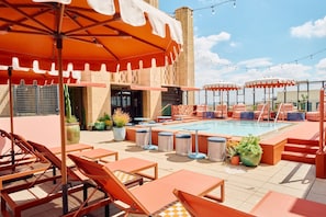 A rooftop pool area with lounge chairs, umbrellas, and potted plants. - STILE Downtown Los Angeles (Los Angeles)