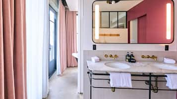 A bathroom with two sinks, a large mirror, and a view of a hallway.