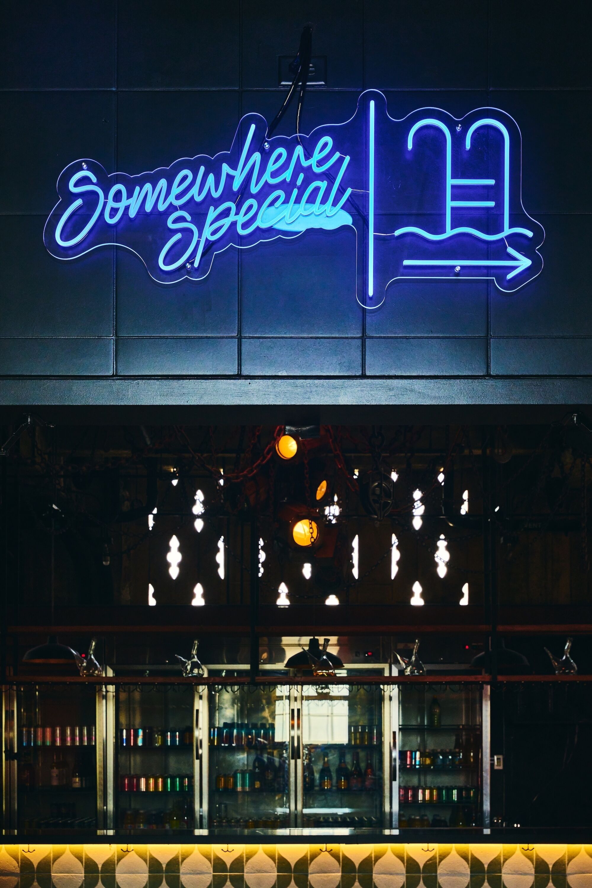 Un letrero de neón con el texto 'Somewhere Special' y una flecha indicadora.