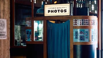 Una cabina fotografica con un cartello che riporta la scritta 'STUDIO QUALITY PHOTOS' e una tenda blu.