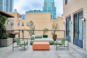 A rooftop patio with a sofa, chairs, and a checkered ottoman. - STILE Downtown Los Angeles (Los Angeles)