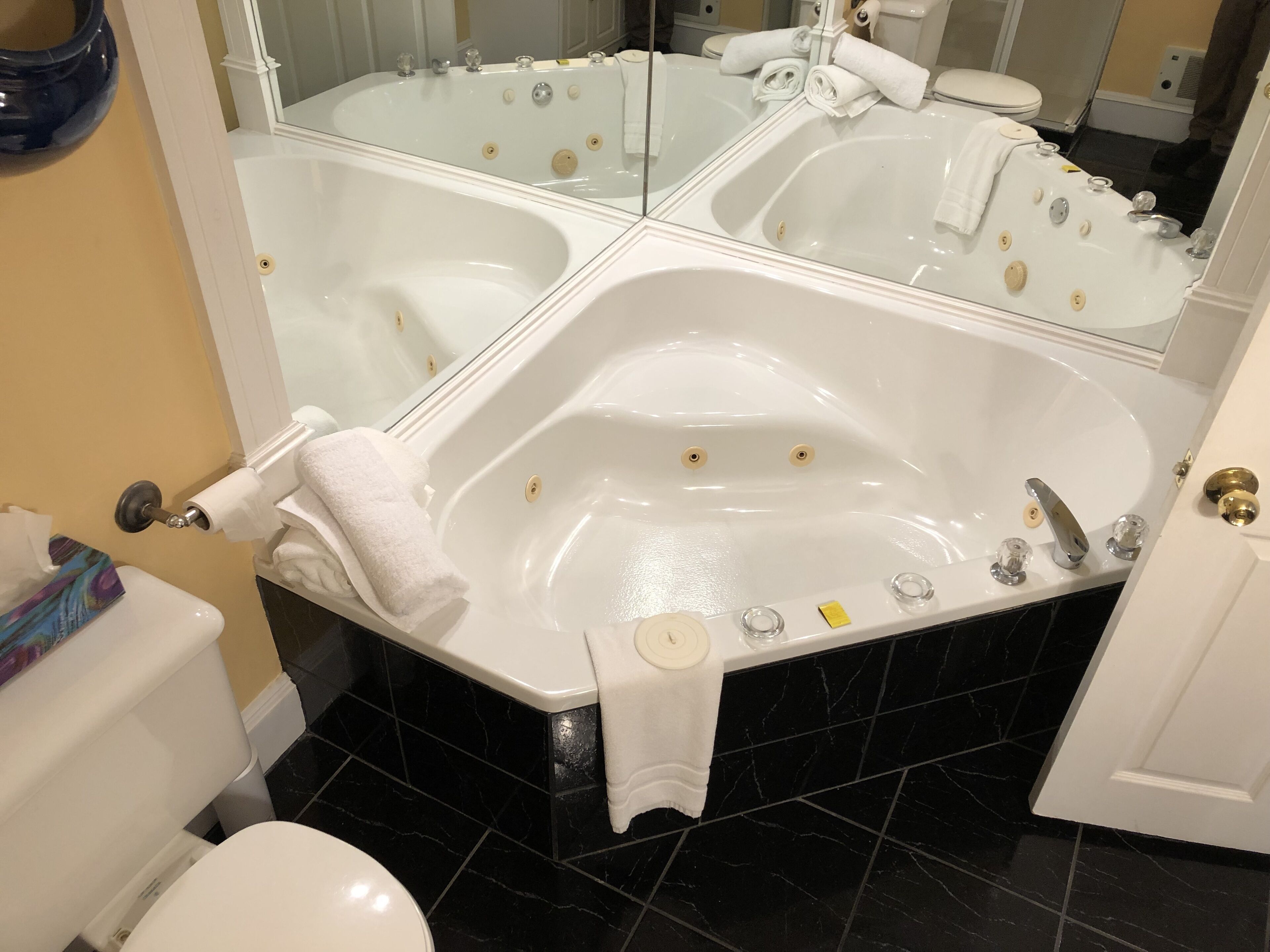 A bathroom with a large freestanding bathtub, a toilet, and a sink.