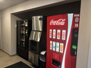 A vending machine area with a Coca-Cola machine, a water dispenser, and a snack vending machine.