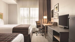 A hotel room with a bed, a desk, a chair, a television, and a window with curtains. - Country Inn & Suites by Radisson, Springfield Southeast (Springfield)