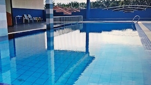 A swimming pool with clear blue water, tiled deck, and a few lounge chairs. - Sun Inns Hotel Equine Seri Kembangan (Seri Kembangan)