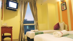 A hotel room with two beds, a television, a small table with a phone, and a window with curtains. - Sun Inns Hotel Equine Seri Kembangan (Seri Kembangan)