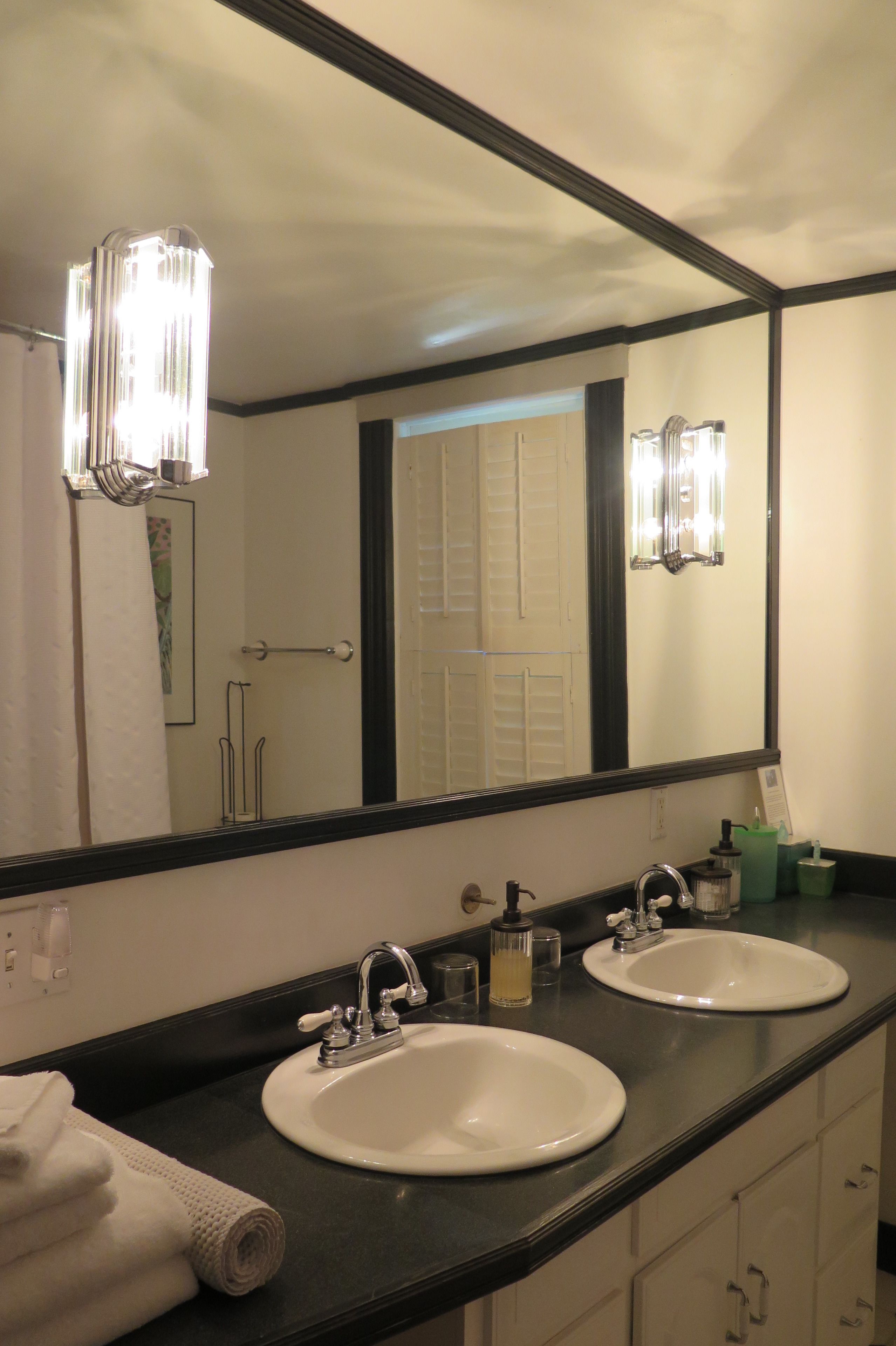 A bathroom with two sinks, a large mirror, and a towel rack.