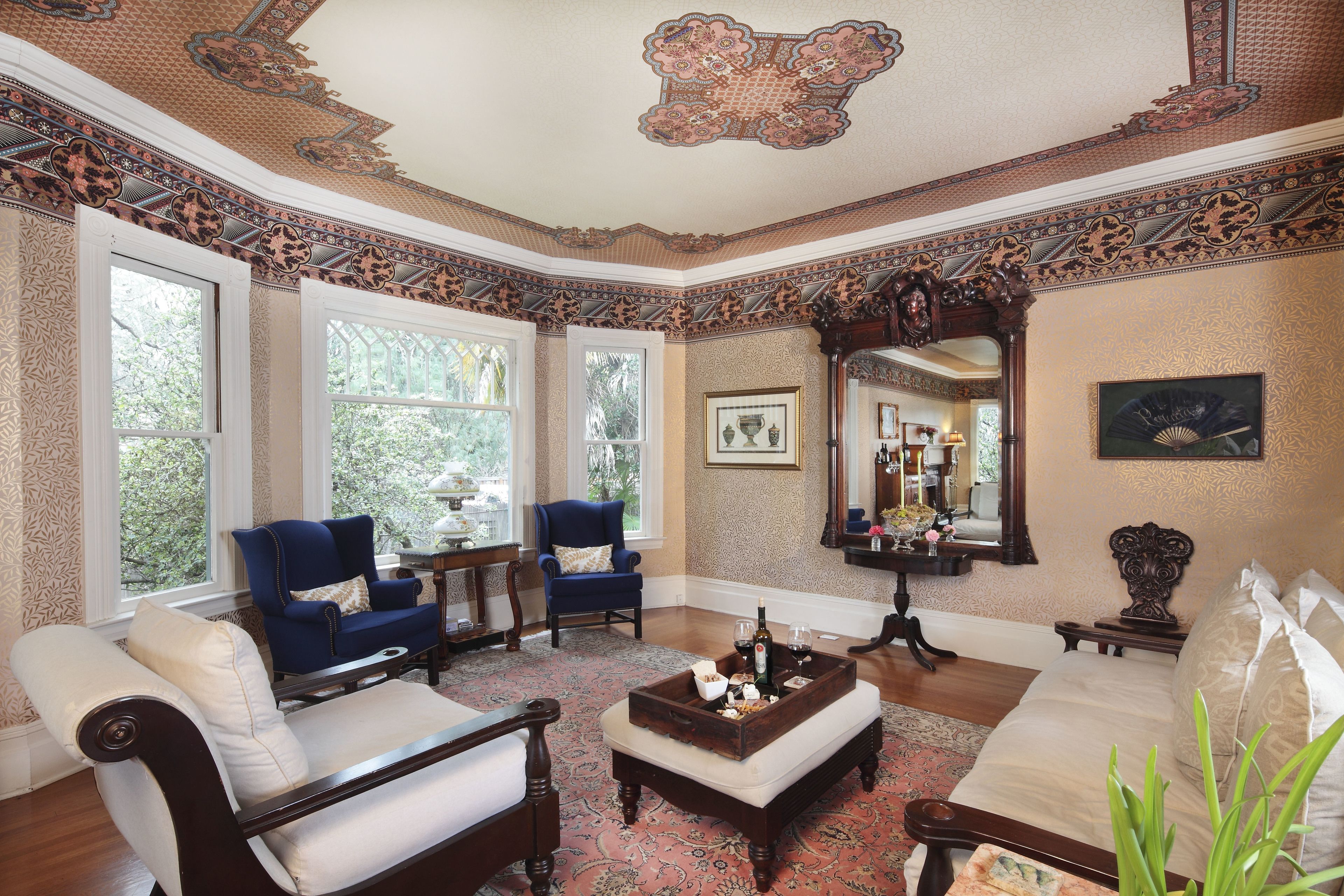 A room with a large window, a blue armchair, a wooden coffee table, and a white sofa.