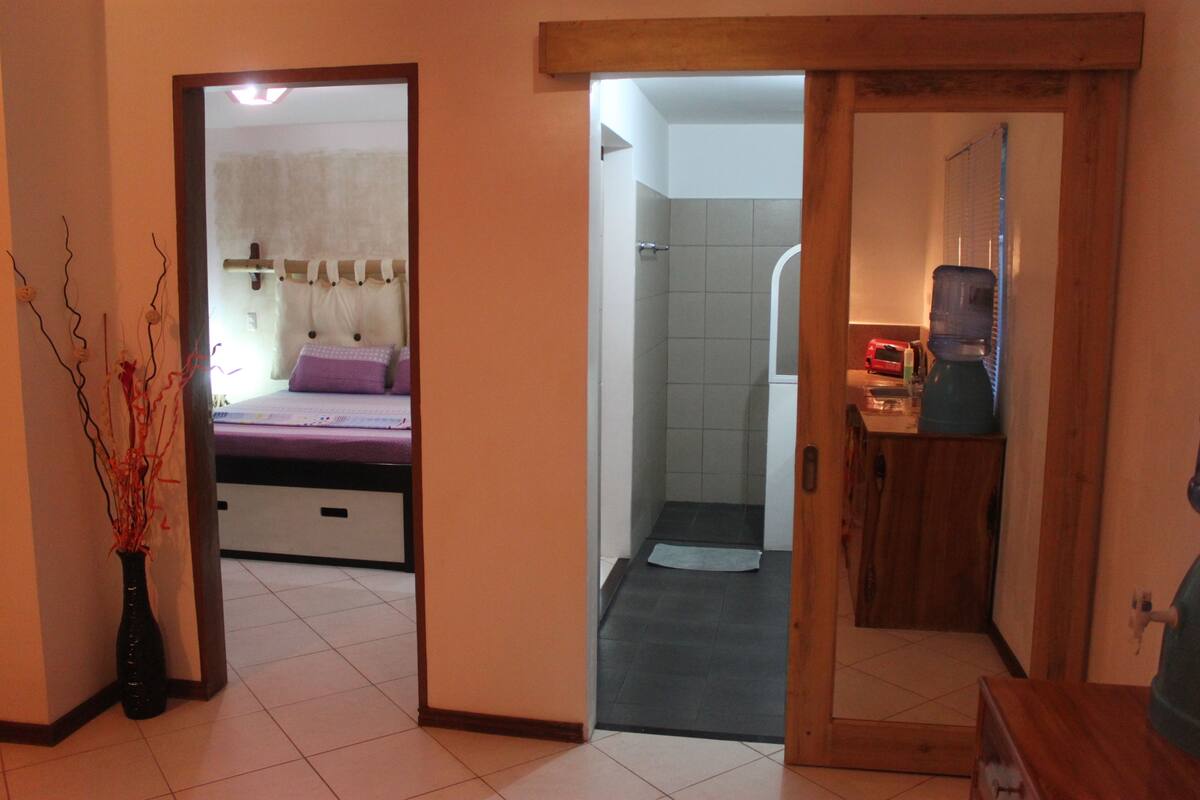 Una habitación de hotel con cama, baño y kitchenette.