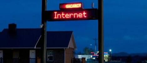 A hotel signboard with "Cody Legacy Inn & Suites" and "Vacancy Internet" displayed.