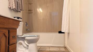 Un baño con inodoro, ducha y bañera.