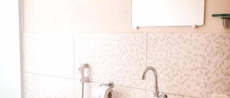 Un baño con lavamanos, inodoro y ducha blancos.