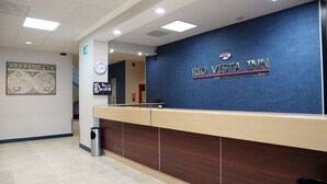 Una mesa de recepción en Rio Vista Inn, con un reloj y una cámara de seguridad encima.