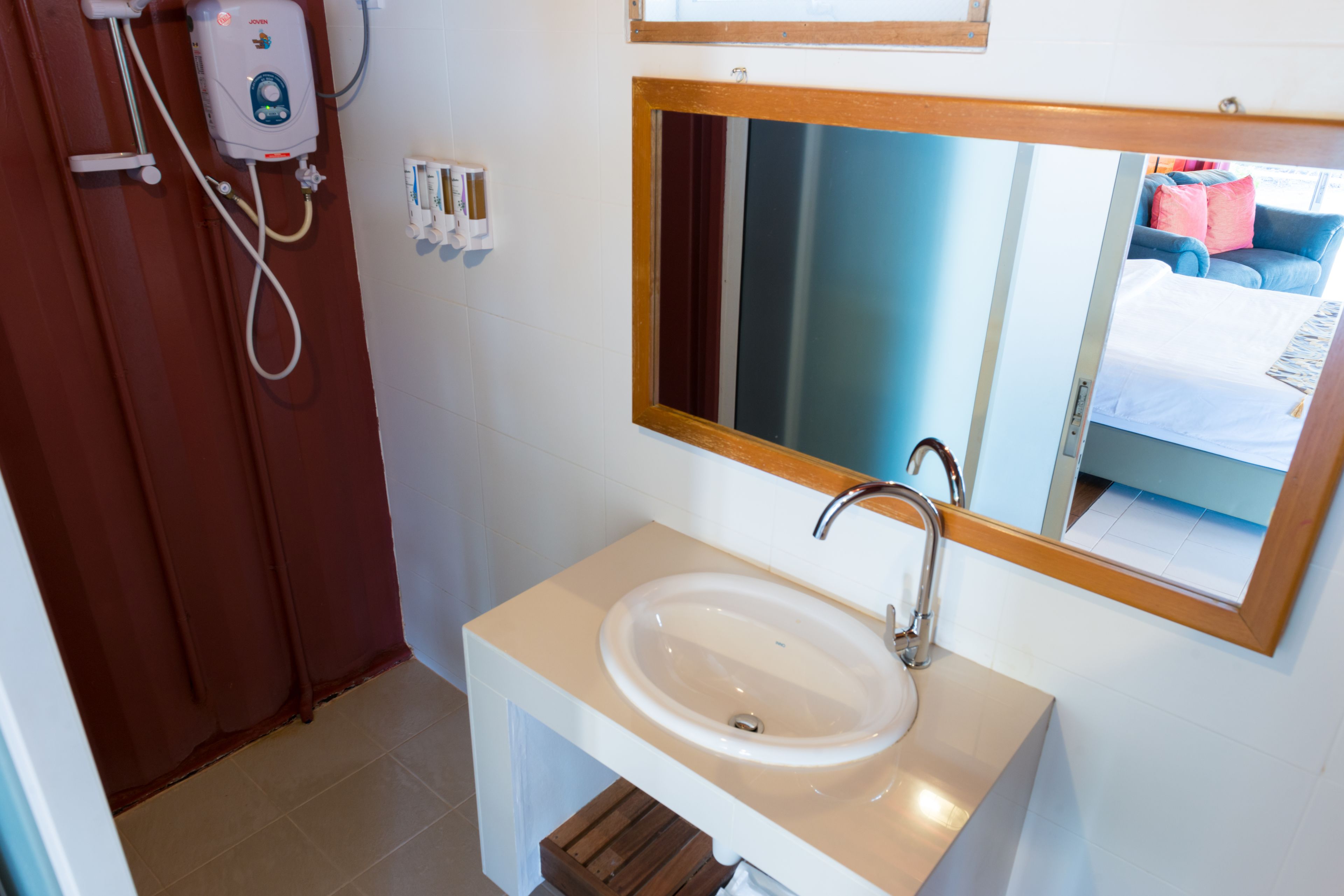 Une salle de bain avec un lavabo, un miroir et une douche.