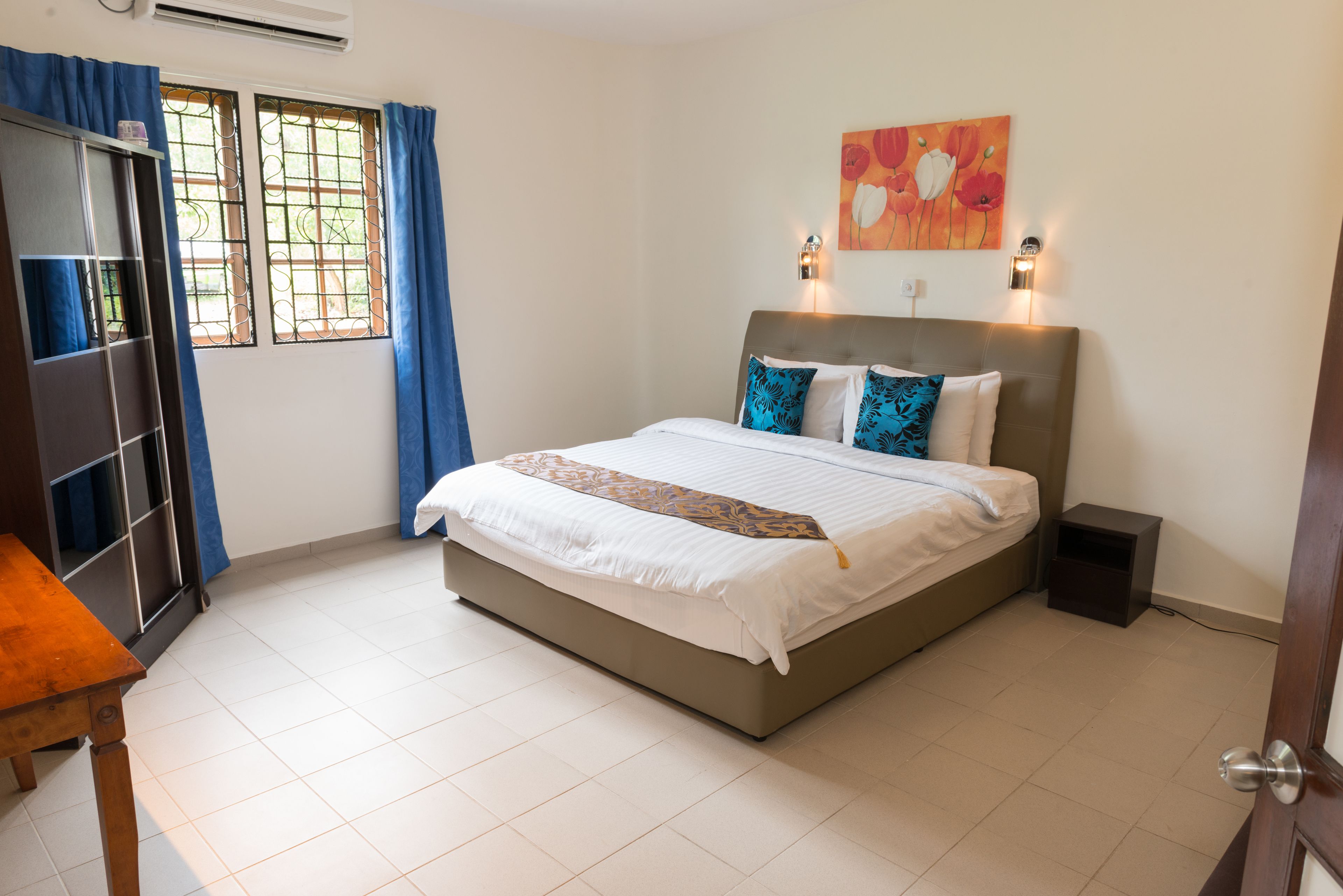 Une chambre à coucher avec un lit, une table de chevet, un bureau et une chaise.