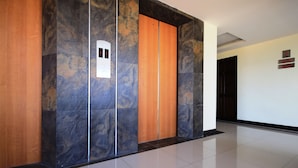 A modern elevator with marble panels and a wooden door. - Airport Resident 2 (Chiang Mai)