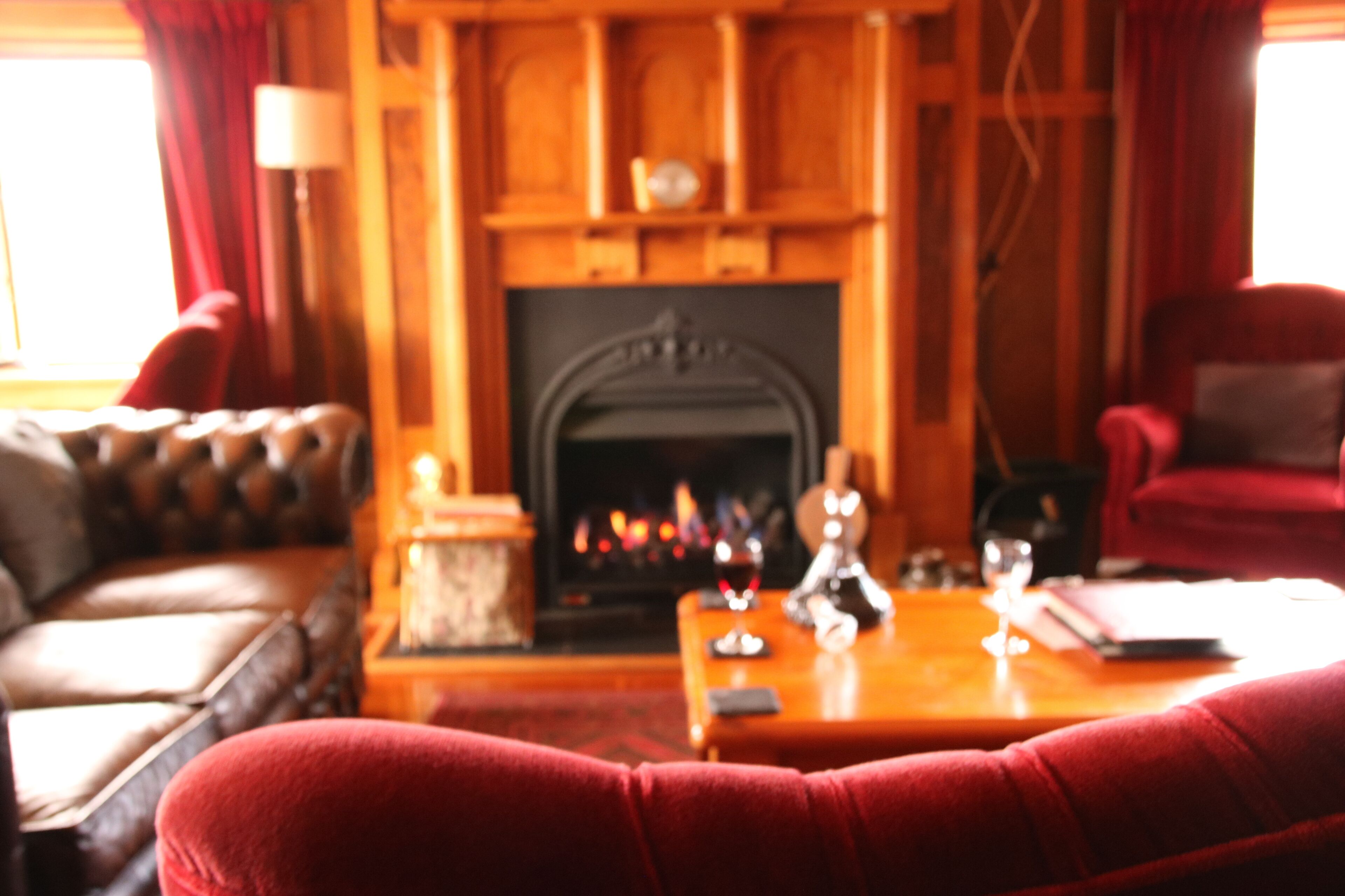 A cozy living room with a fireplace, leather sofa, and a wooden coffee table.