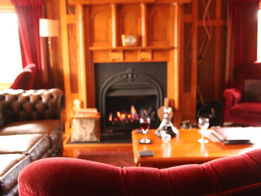 A cozy living room with a fireplace, leather sofa, and a wooden coffee table.