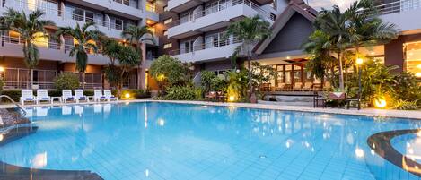 Een buitenzwembad en ligstoelen