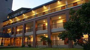 A multi-story hotel with balconies, a well-maintained lawn, and a clear sky. - Authong Residence Pattaya (Pattaya)