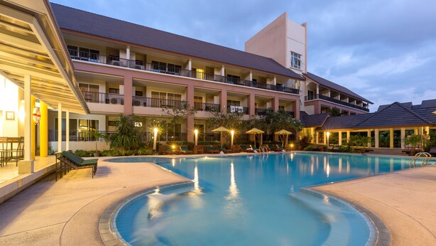 A hotel with a swimming pool, multiple balconies, and outdoor seating areas. - Authong Residence Pattaya (Pattaya)